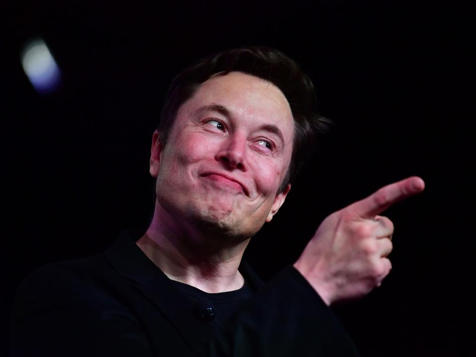 Elon Musk making a grimace and pointing a finger.