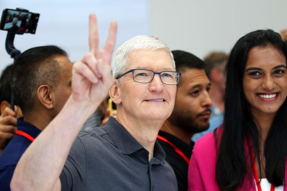 Apple CEO Tim Cook gives the peace sign.