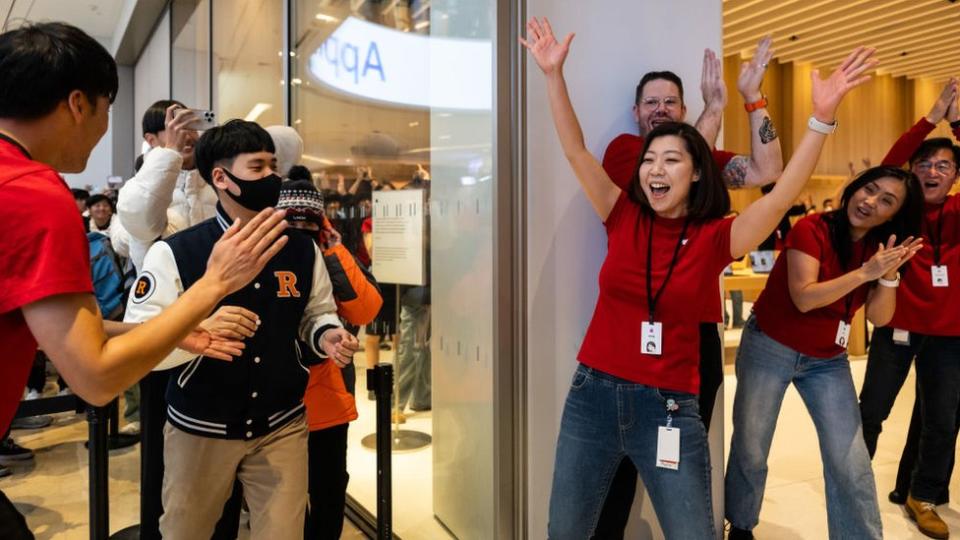 Employees applaud as customers enter the new Apple Inc. store inside the Starfield mall during its opening in Hanam, South Korea, on Saturday, Dec. 9, 2023.