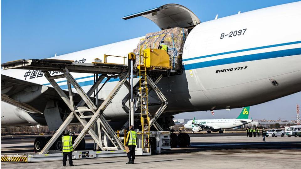Staff members load cargo onto an aircraft at a Chinese airport.