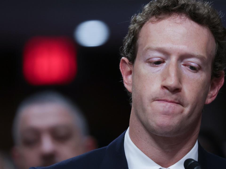 Mark Zuckerberg looking down whilst wearing a suit