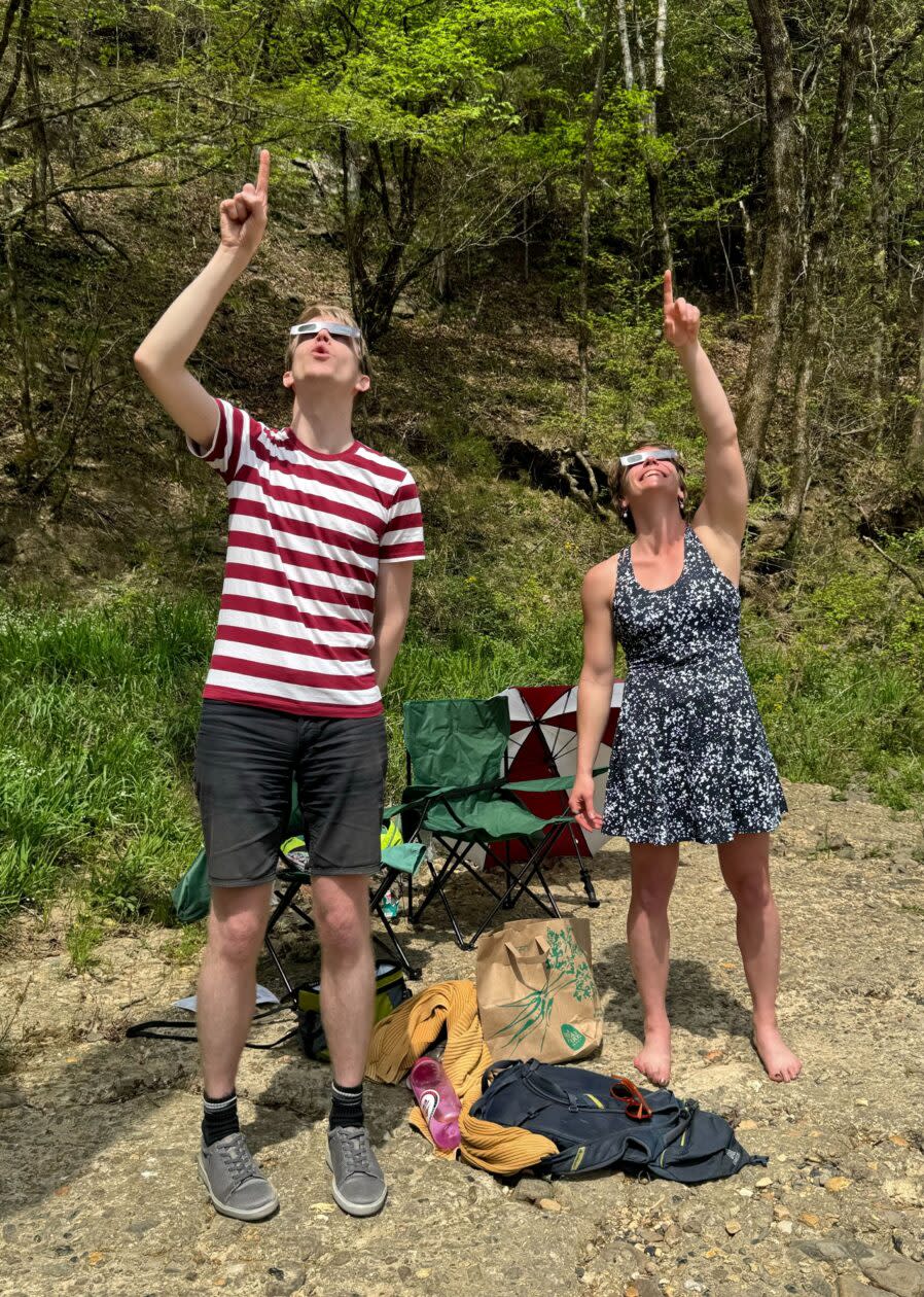 Observers at Cossatot River State Park in Arkansas wear protective glasses as they point at the partially eclipsed sun. (GeekWire Photo / Kevin Lisota)