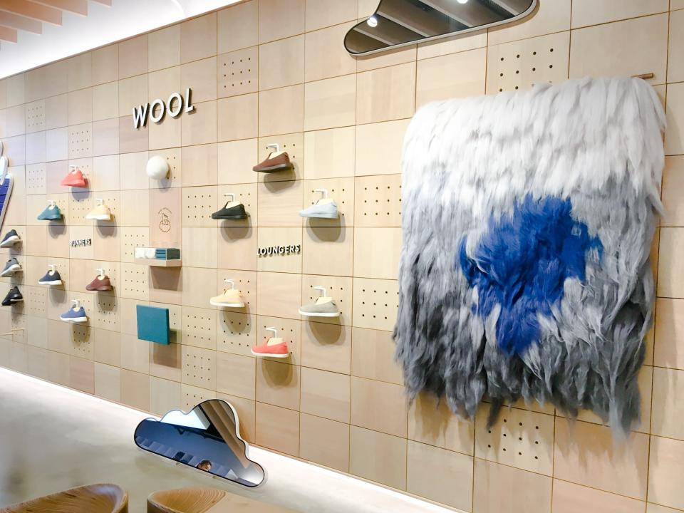 Multiple pairs of sneakers lined up on a wall in Allbirds' first store in Soho, New York City.