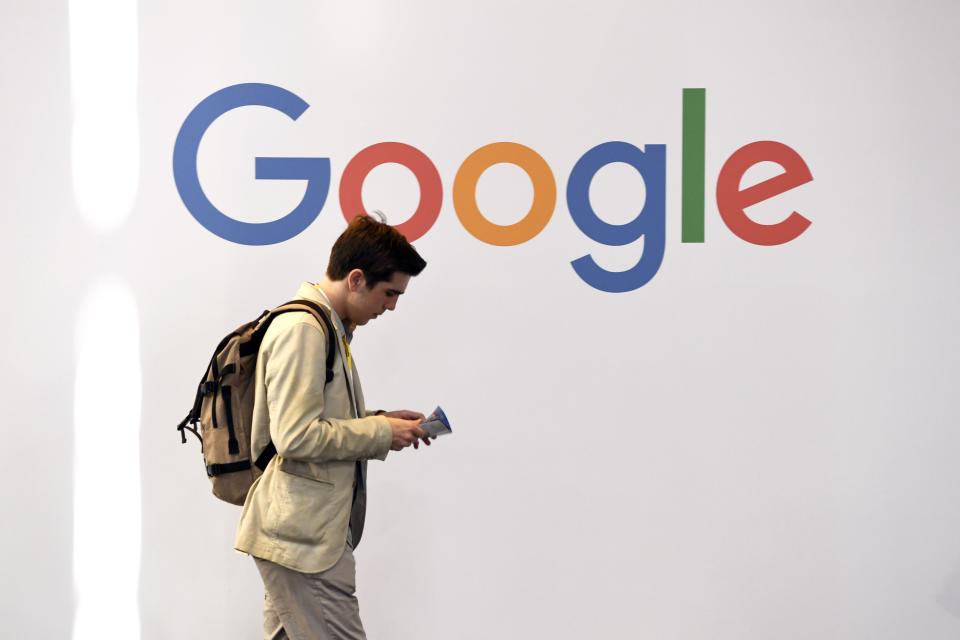 Man walking by Google logo
