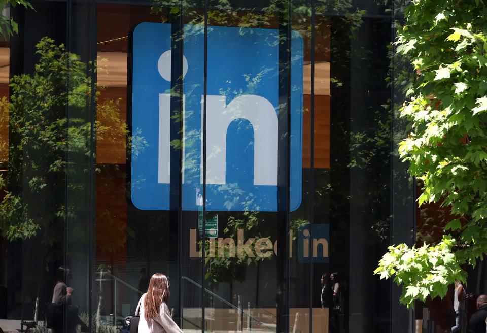 A pedestrian walks by a sign at a LinkedIn office on July 26, 2023 in San Francisco, California.