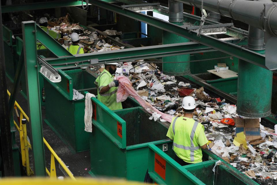 Recycling sorters at Recologys Recycle Central sort out pieces of flimsy and film plastic destined for landfill in 2019 in San Francisco