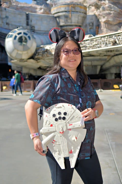 Person holding Millennium Falcon in front of the Millennium Falcon.