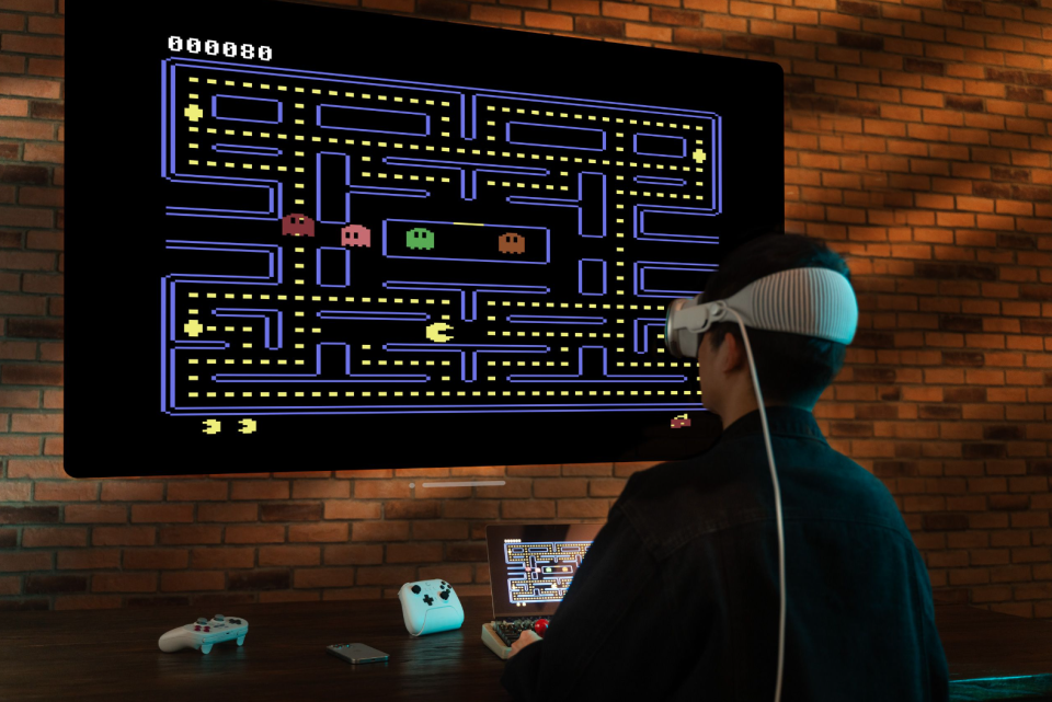 A person wearing a headset and playing Pac-Man.