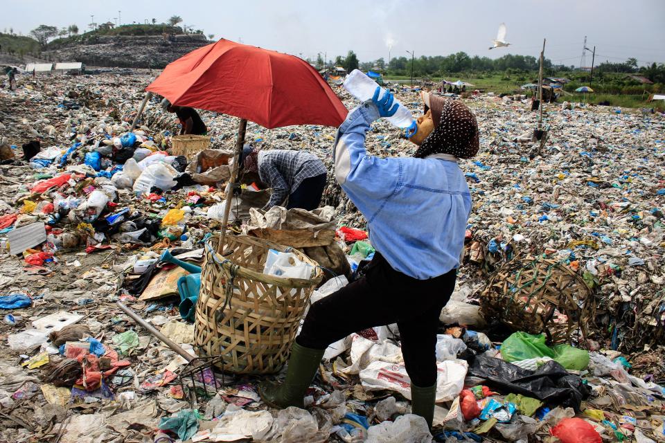 A scavenger drinks water while collecting plastic waste to sell to a recycling center at a landfill in Medan, North Sumatra, Indonesia in March 2024