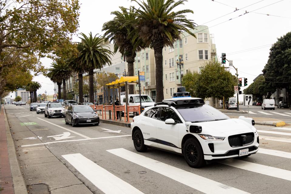 A Waymo self-driving taxi crosses an intersection in San Francisco.