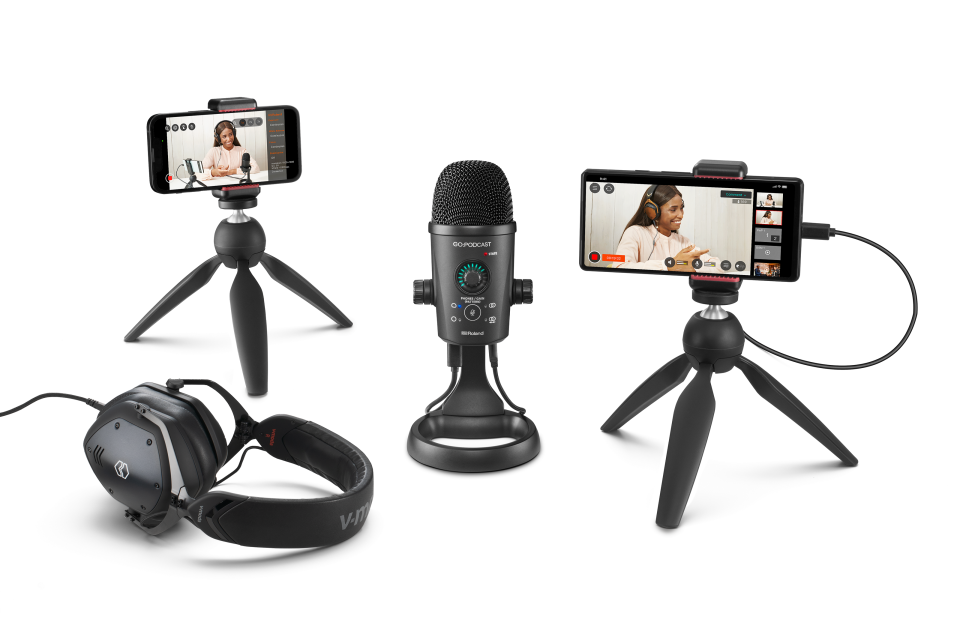 Product marketing photo for the Rode Go:Podcast mobile studio. At center is a desktop microphone, and it's flanked by two smartphones on mini tripods (showing the podcast video on their screens) and a pair of headphones.