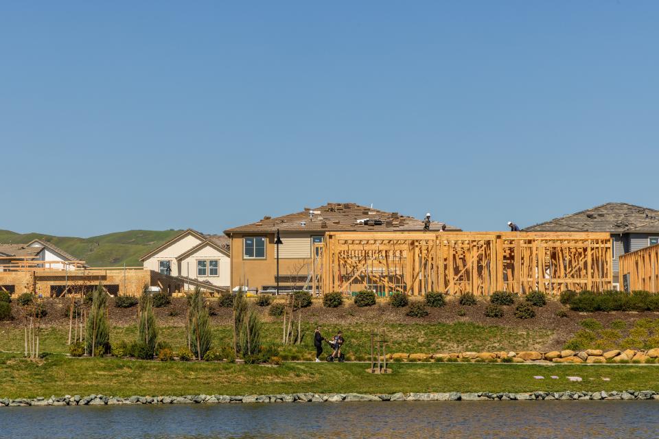 One Lake neighborhood with houses being built in front of a man-made river.