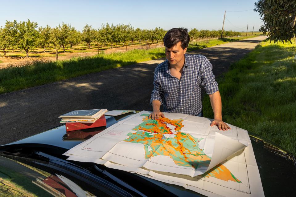 Jan Sramek looking over a map on top of his car.